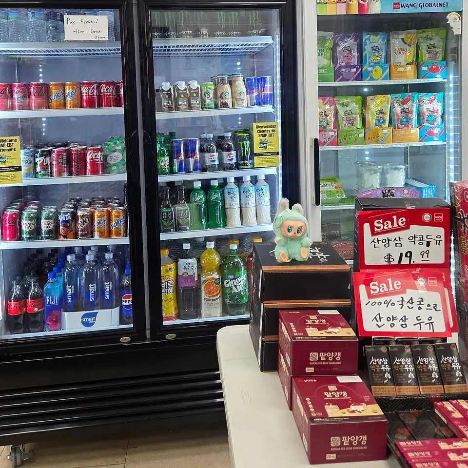 Glass-door coolers of sodas, aloe drinks and Korean rice drinks, a table of red bean yanggaeng and ginseng soy milk on sale